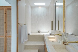 A modern bathroom with a freestanding bathtub, two sinks, and a large mirror. - Mareo Villa (Pecatu)