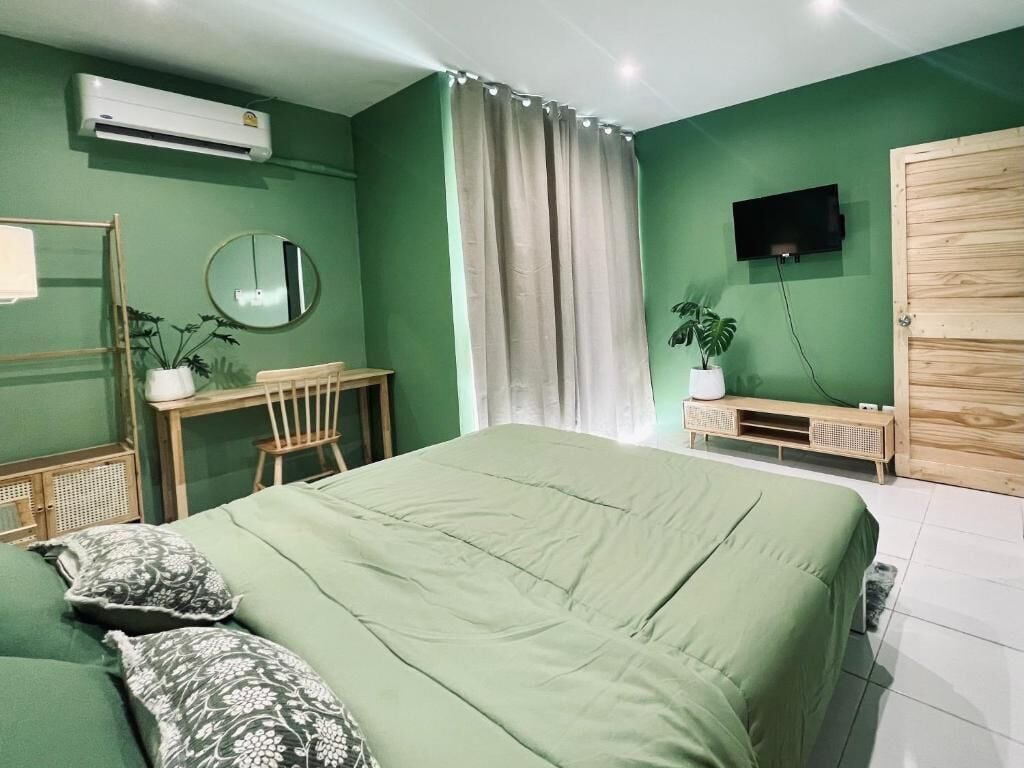 A room with a bed, a desk, a chair, a television, and a wardrobe.