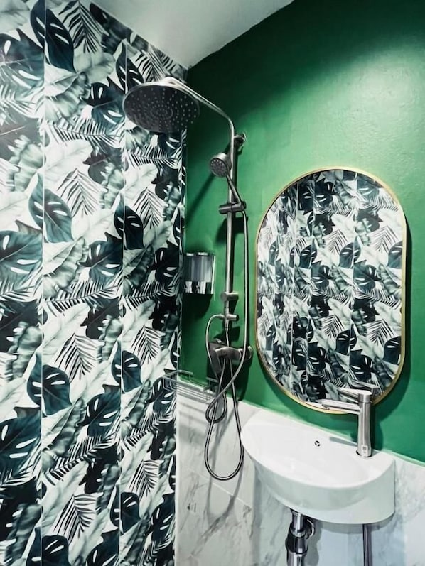 A bathroom with a shower, a sink, and a mirror. - Midori Rawai (Rawai)