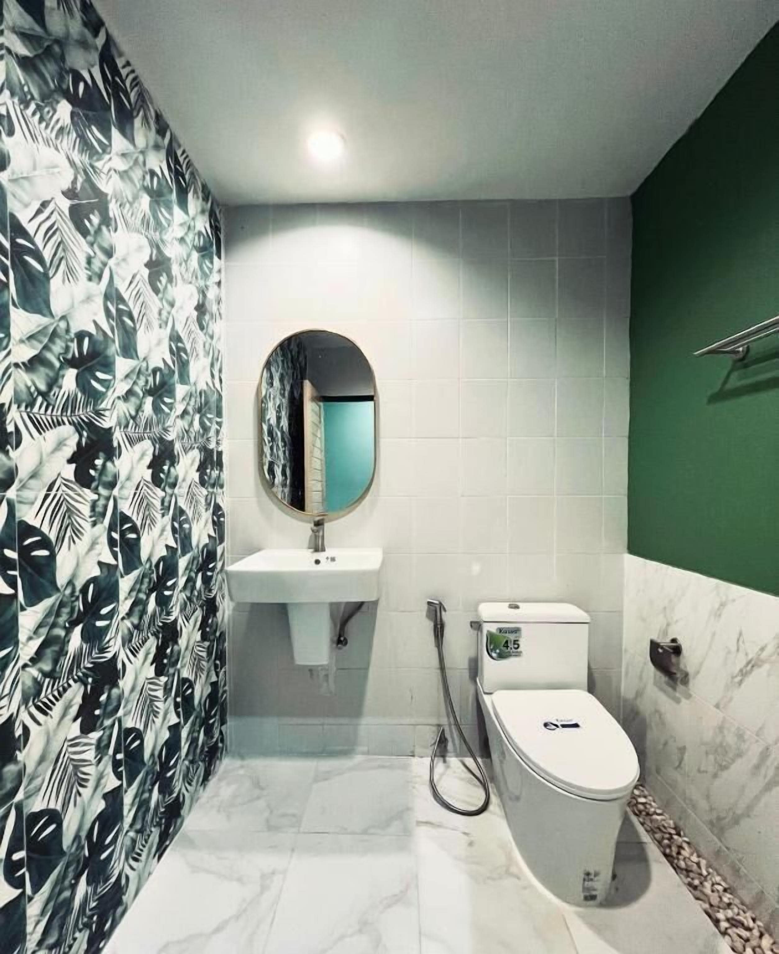 A bathroom with a toilet, sink, and mirror.
