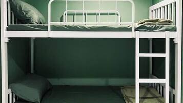 Uma cama beliche com estrutura de metal branco e roupa de cama verde.