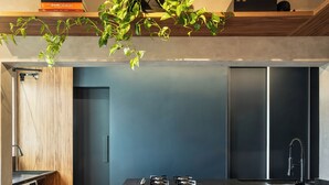 Een moderne keuken met een centraal eiland, houten vloer en een ingebouwde wasmachine.