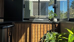 Een moderne keuken met een houten aanrecht, een inbouwvaatwasser en een groot raam met uitzicht.