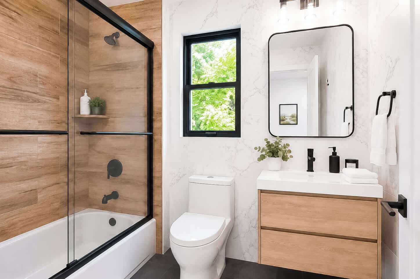 Un bagno moderno con doccia a filo pavimento, servizi igienici e mobile lavabo con specchio.