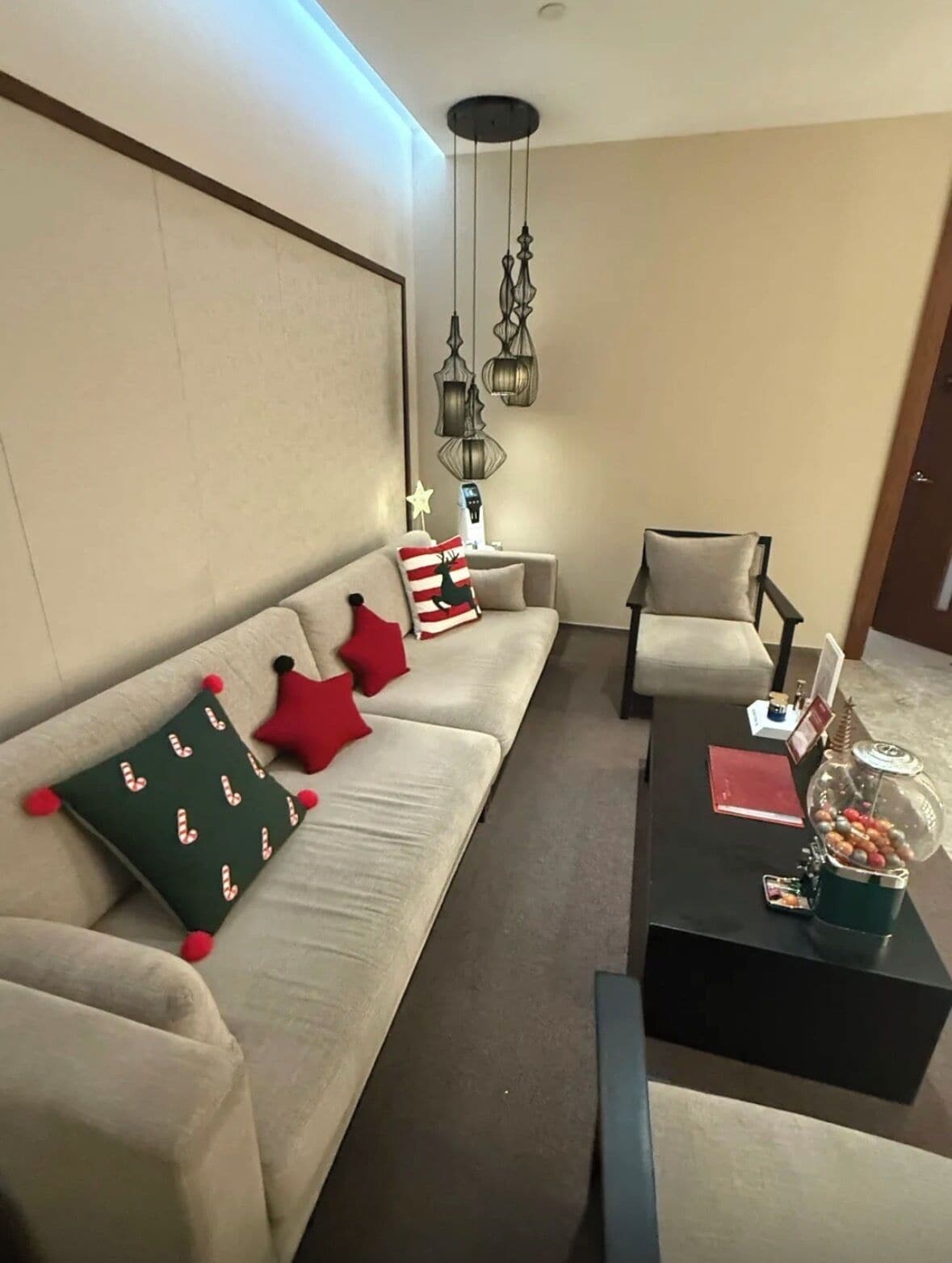 Una sala de estar moderna con un sofá, sillones, una mesita de centro y cojines decorativos.