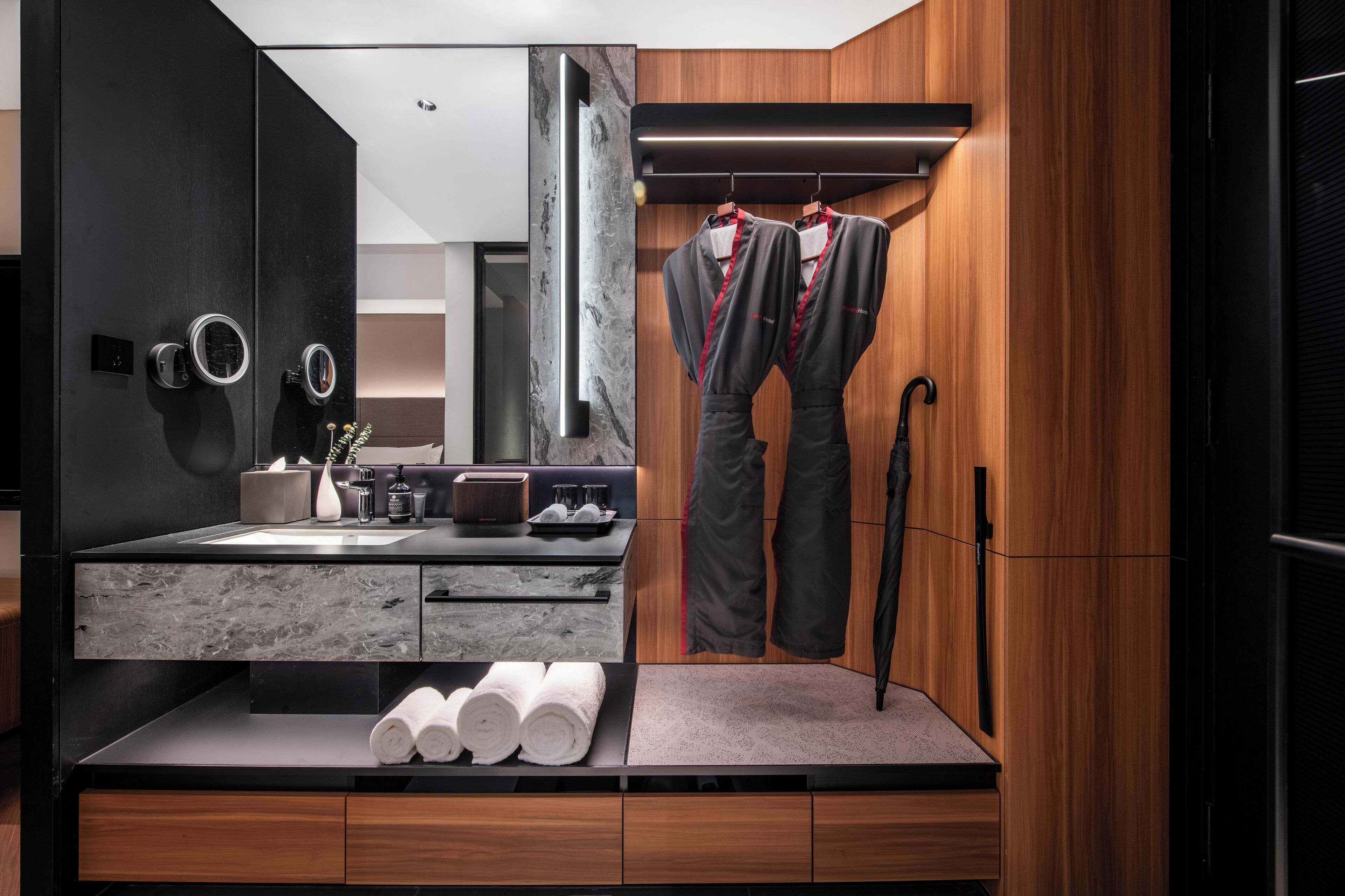 A modern bathroom with a vanity, towel rack, and a mirror.