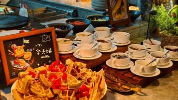 Buffet com waffles, sopas em tigelas e placa de waffles.