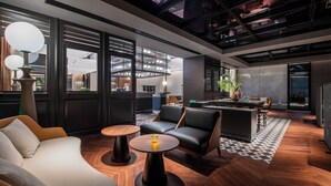A modern interior with a sofa, two round tables, a bar area, and a view of the kitchen. - Intercity Shanghai Xujiahui (Shanghai)