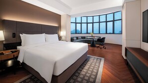 A modern hotel room with a large bed, a desk, a sofa, and a TV. - Intercity Shanghai Xujiahui (Shanghai)