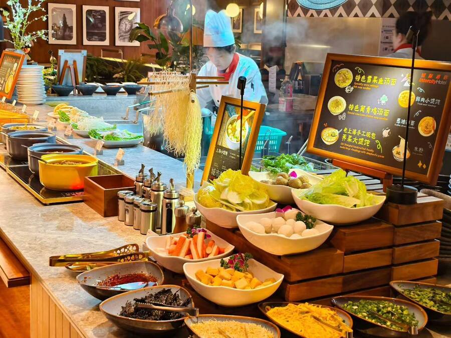 A buffet setup with various food items and condiments.