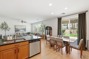 A modern kitchen with a dining area, large windows, and a view of the outside. - Family-Friendly 4BR Home, 30+ Night Stays -  Loft, Big Backyard (Gilbert)