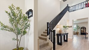Eine Treppe mit schwarzer Geländer, einem Blumentopf und einer hellen Wand.