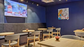 L’intérieur d’un restaurant avec des banquettes, des tables rondes et des chaises.