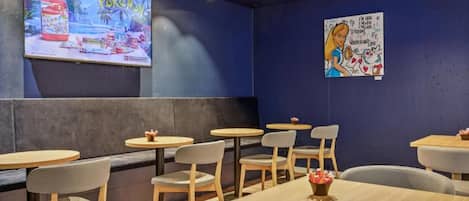 A restaurant interior with booths, round tables, and chairs.