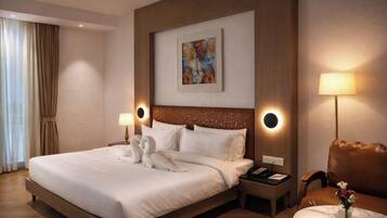 A hotel room with a large bed, two bedside lamps, a headboard with a circular light, a painting on the wall, and a small table with a vase of flowers.