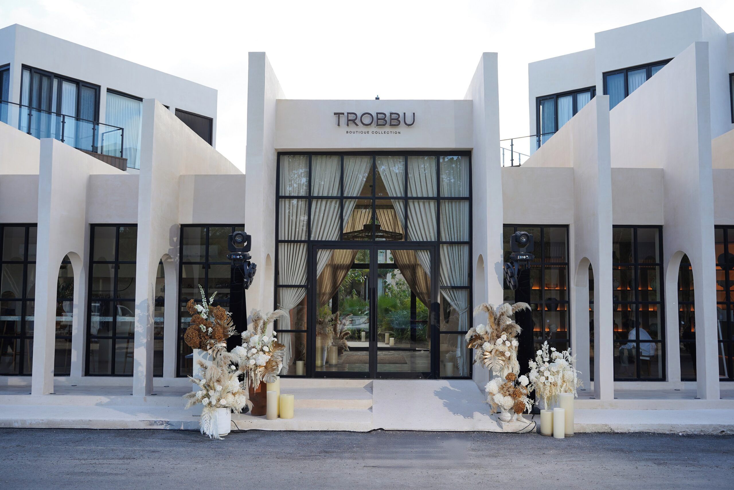 Un edificio moderno con el letrero 'TROBBU BOUTIQUE COLLECTION' sobre la entrada.