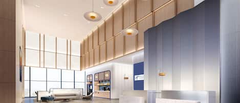 A spacious lobby with a reception desk, seating area, and a coffee station.