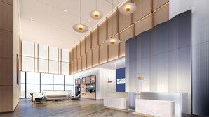 Um hall amplo com balcão de atendimento, área de estar e um espaço para café.