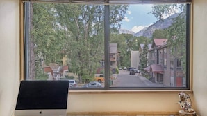 Ein Zimmer mit großem Fenster mit Blick auf eine Straße und Berge.