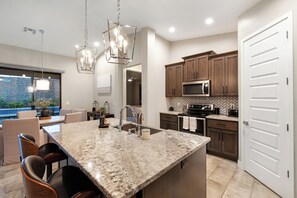 A modern kitchen with granite countertops, stainless steel appliances, and wooden cabinets. - Three bedroom  house with beautiful pool (Lake Havasu City)