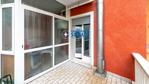 A building with large glass doors, a metal pipe, and a red wall. - Minetto / city center apt *Via Bafile* (Jesolo)