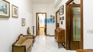 A hallway with a sofa, a wooden cabinet, and framed pictures on the walls. - Minetto / city center apt *Via Bafile* (Jesolo)