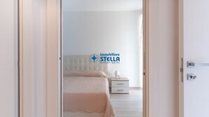 Un dormitorio con cama, mesita de noche y logotipo en la pared.