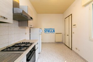 Una cocina con estufa, horno y campana extractora.