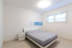 Ein Schlafzimmer mit Bett, Nachttisch und Fenster.