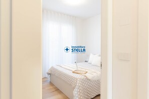 Ein Schlafzimmer mit einem Bett, einem Nachttisch und einem fenster mit Vorhängen.