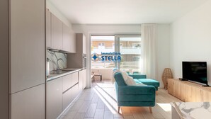 Un apartamento moderno con cocina, sala de estar y balcón.