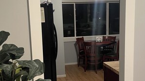 A hallway leading to a dining area with a table and chairs, a refrigerator, and a plant. - Convenient 2-bedroom House in downtown Bremerton Perfect for your Getaway (Bremerton)