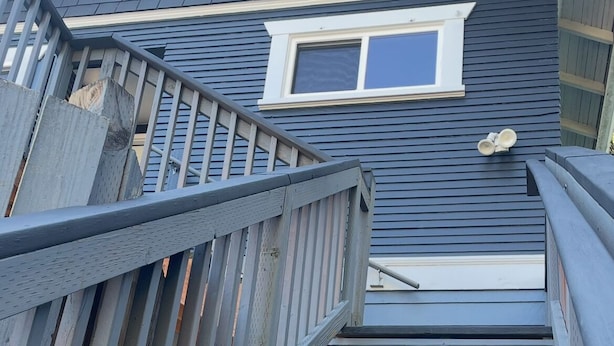 A staircase leading to a house with a dark shingled roof and a window. - Convenient 2-bedroom House in downtown Bremerton Perfect for your Getaway (Bremerton)