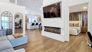 A modern living room with a fireplace, a TV, and a dining area. - Palm Vista Luxury Resort • Heated Pool
• Near Theme Parks• 4BR/2BA (Davenport)