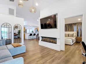 A modern living room with a fireplace, a TV, and a dining area. - Palm Vista Luxury Resort • Heated Pool
• Near Theme Parks• 4BR/2BA (Davenport)