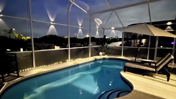 An indoor swimming pool with a covered area and lounge chairs. - Palm Vista Luxury Resort • Heated Pool
• Near Theme Parks• 4BR/2BA (Davenport)