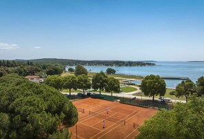 A tennis court with a view of a lake and hills. - Holiday apartment with pool (Rovinj)
