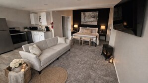 A compact living space with a sofa, dining table, and kitchen area. - Riverside apartment in Bay City perfect for your next getaway (Bay City)