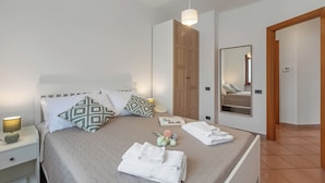 A neatly made bed with pillows, a bedside lamp, and towels. - Villa Adriana Capalbio With A/c, BBQ and Parking (Capalbio)