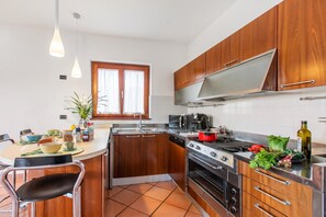 Una cocina con armarios de madera, estufa y lavamanos.