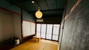 Een traditionele Japanse kamer met tatami vloerbedekking, schuifdeuren en een hangende papieren lantaarn.