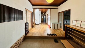 Een klassiek interieur met een houten vloer, schuifdeuren en een hanglamp.