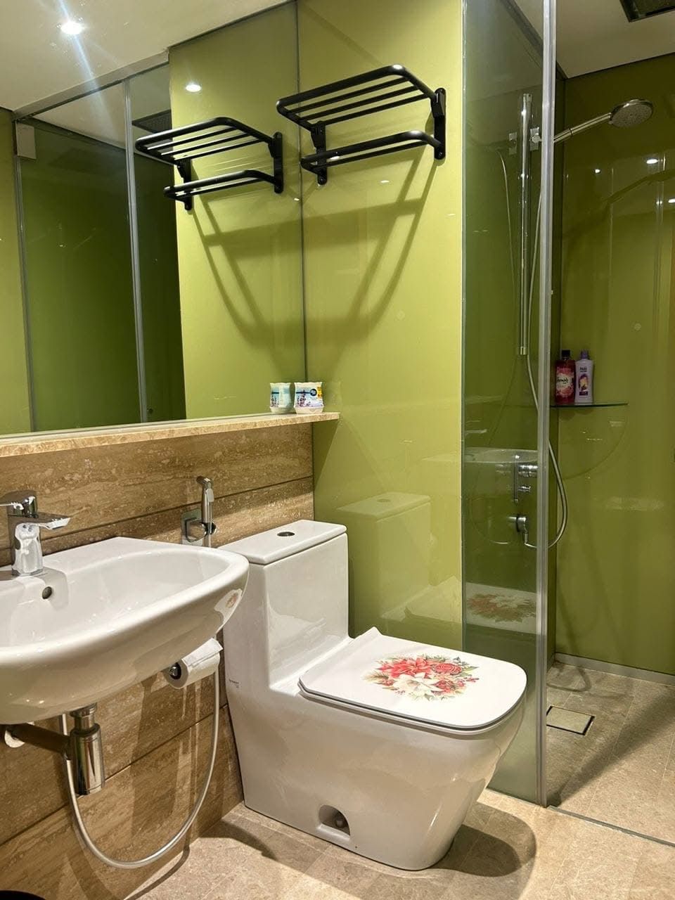 A modern bathroom with a sink, toilet, and glass shower enclosure.