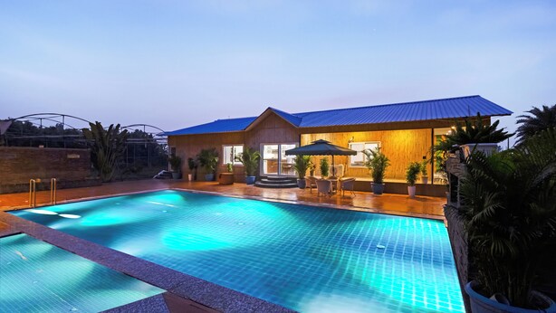Une piscine avec un bâtiment en bois en arrière-plan.