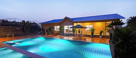 Una piscina con un edificio de madera al fondo.