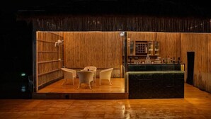Une pièce avec un mur en bois, un coin bar et des sièges disposés de manière à créer un espace convivial.