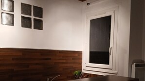 Una cuina amb taulell de fusta, un rentaplat i una finestra, juntament amb un armari blanc.