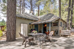 Eine Hütte mit einer Veranda, einem runden Tisch und zwei Stühlen.
