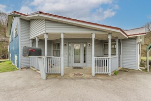 Une maison à deux étages avec un porche, une boîte aux lettres et une porte d’entrée.