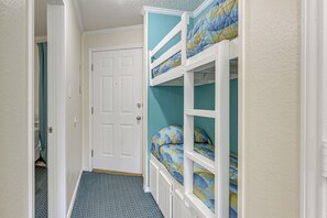 Ein Zimmer mit Etagenbetten, einer Tür und einem gemusterten Boden.
